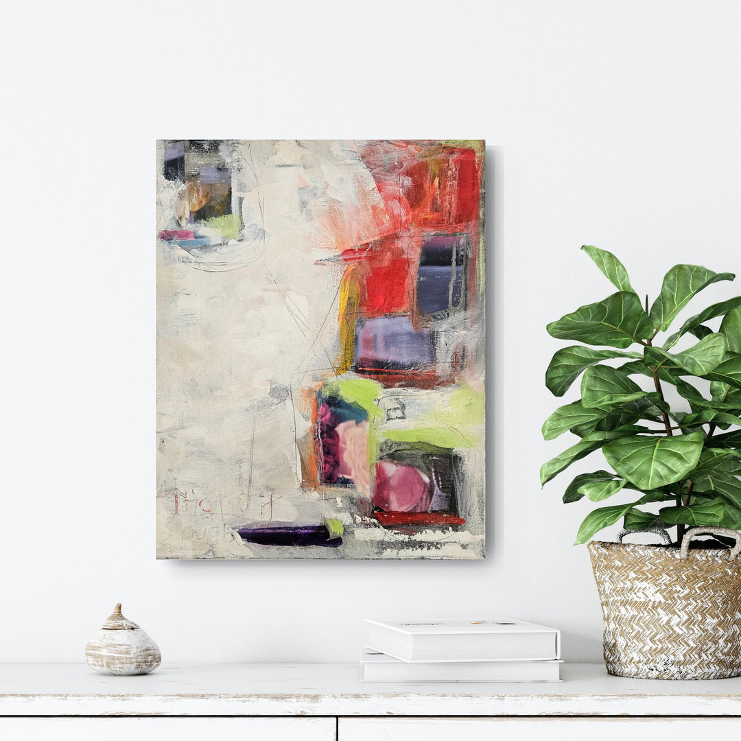 Abstract art piece with colorful geometric shapes on a textured background on white wall above a shelf