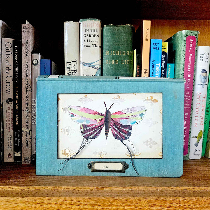Handmade butterfly moth collage in a vintage book frame. Eco-friendly wall art made from recycled magazines. A unique gift for nature lovers.”