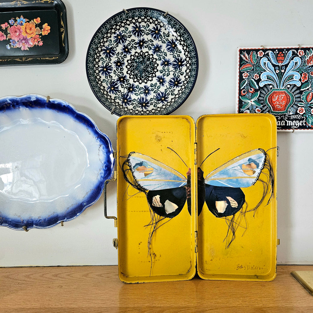 butterfly collage artwork made from recycled magazine pages set into toolboxes
