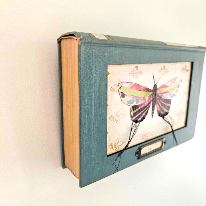 Lily is a handmade butterfly moth collage in a vintage book frame. Eco-friendly wall art made from recycled magazines. A unique gift for nature lovers.